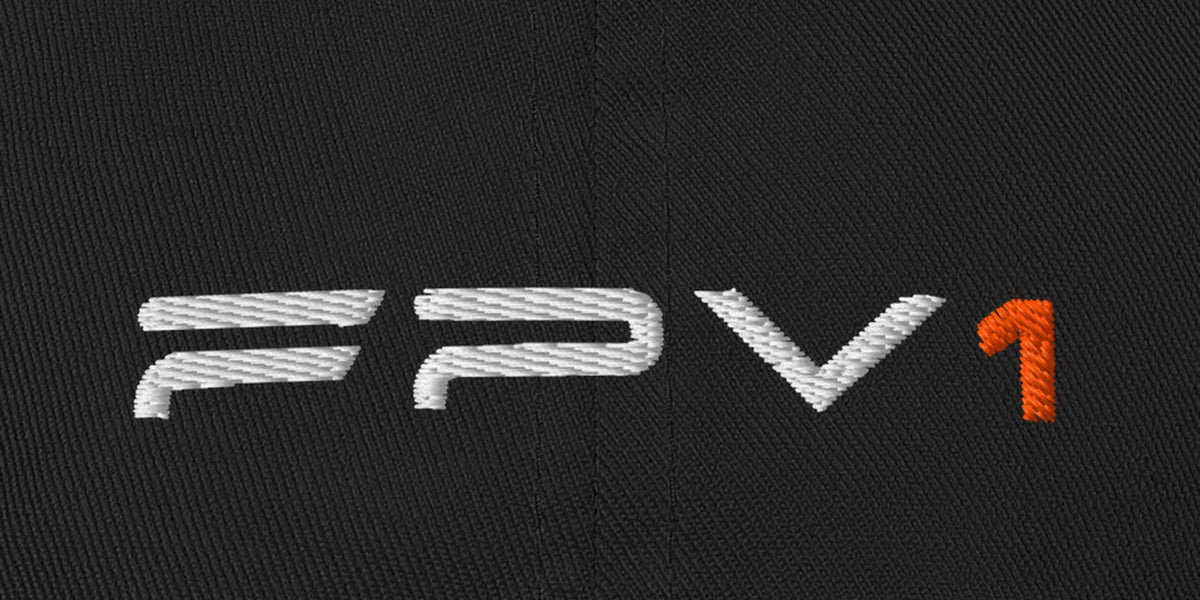 Black FPV1 embroidered cap, close-up of the embroidered thin wordmark with orange 1