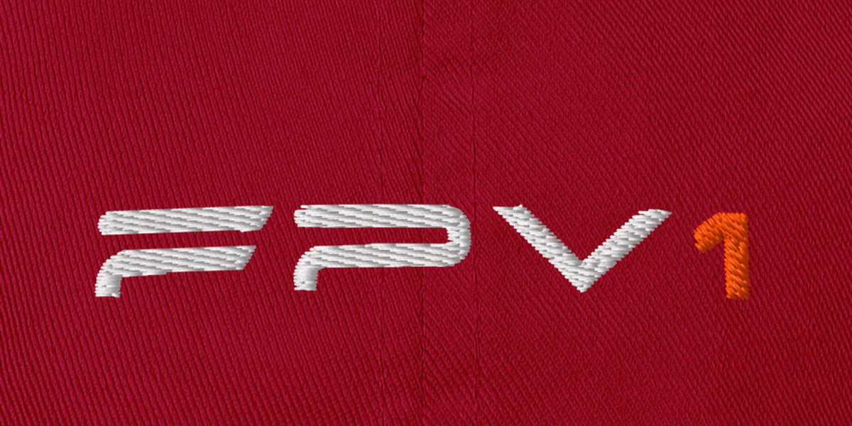 Cranberry FPV1 embroidered cap, close-up of the embroidered thin wordmark with orange 1