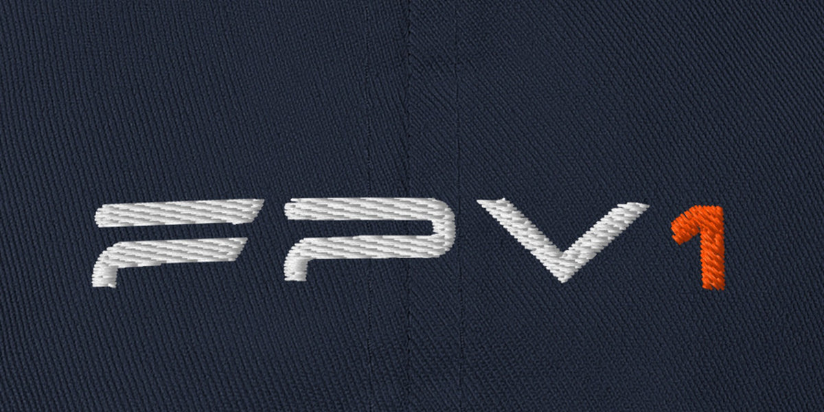 Navy FPV1 embroidered cap, close-up of the embroidered thin wordmark with orange 1